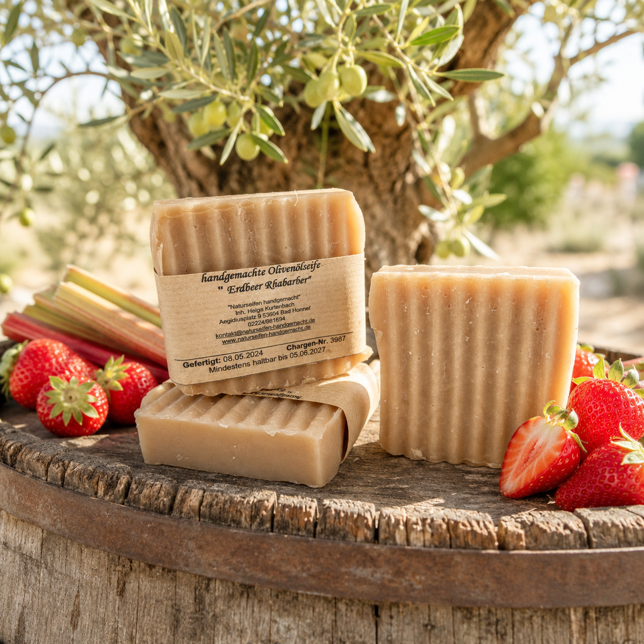 Handgemachte Olivenölseife Erdbeer Rhabarber mit Erdbeeren, Oliven und Olivenzweigen in mediteraner Dekoration