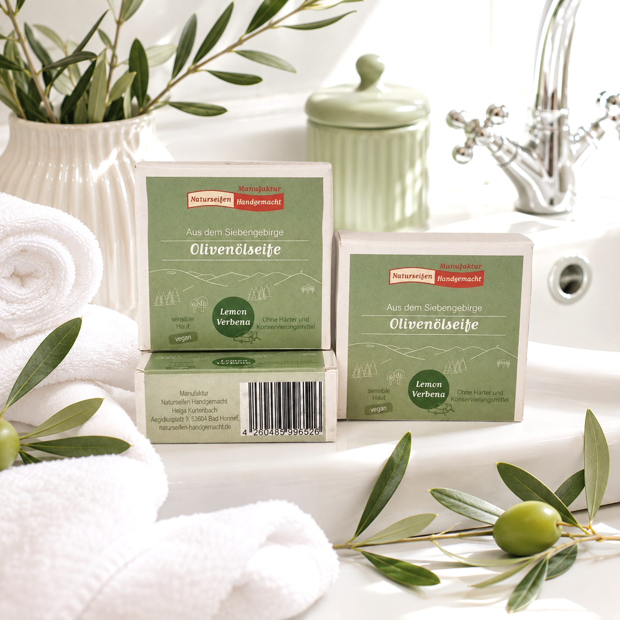 Drei in Pappschachtel verpackte, handgemachte Olivenölseife Lemon verbena, im Badezimmer