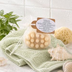 .Eine ovale mit Noppen in weißem Organzabeutel eingepackte handgemachte Olivenölseife Lemon Verbena